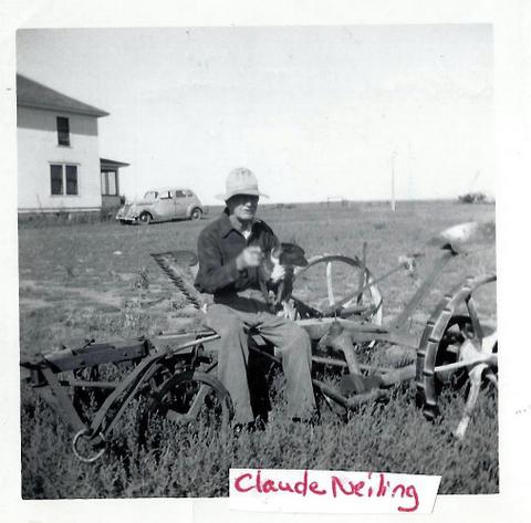 Man on plow holding dog