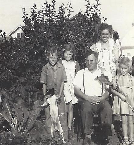3 children and two adults outside with dog