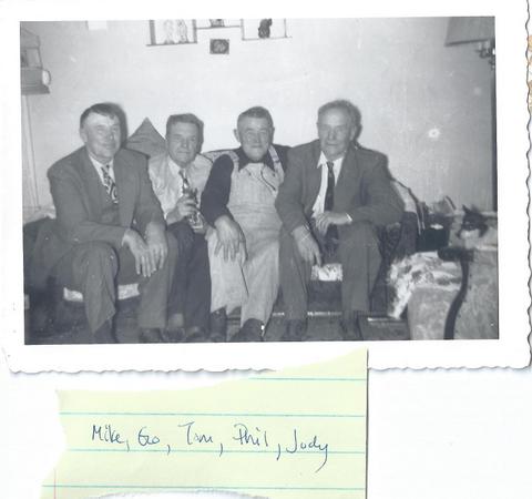 Four men on sofa with dog on chair